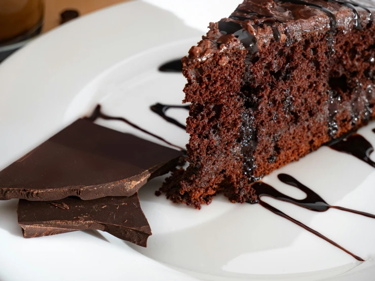 a slice of cake with chocolate sauce sitting on a plate