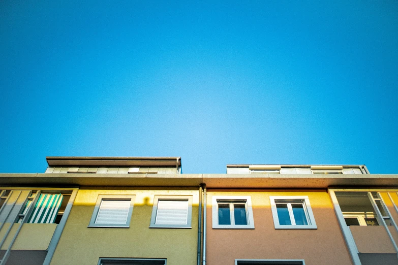 a building with windows is seen under the blue sky