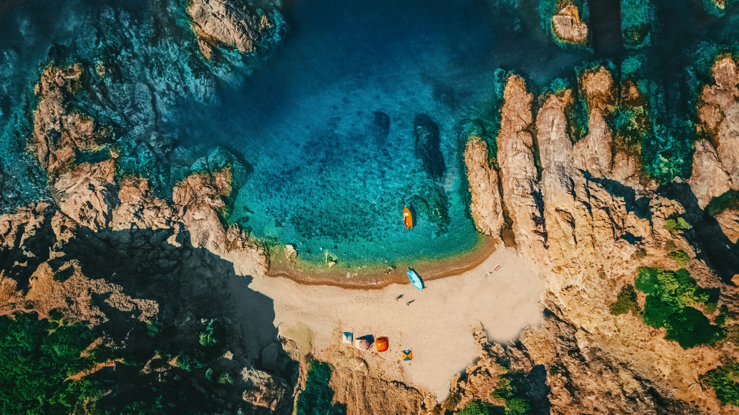 aerial view of several small boats in a blue lagoon