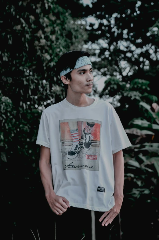 the young man stands next to trees in a park