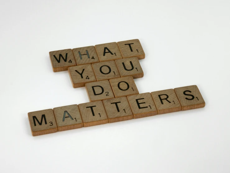 two scrabble tiles are stacked in the shape of letters