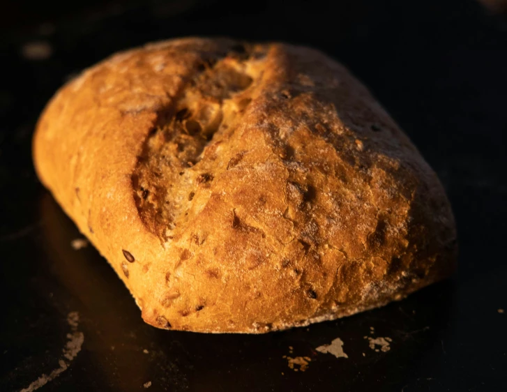 a loaf of bread sitting on a black surface