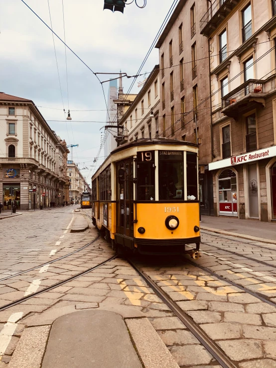 a trolley on a city street with buildings and people