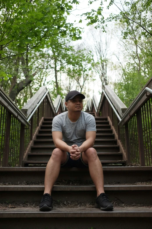 a man sitting on some steps in front of a tree