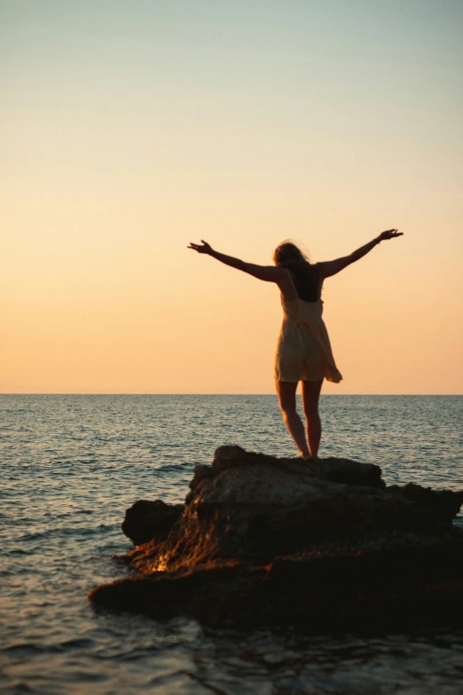 a woman standing on rocks in front of water