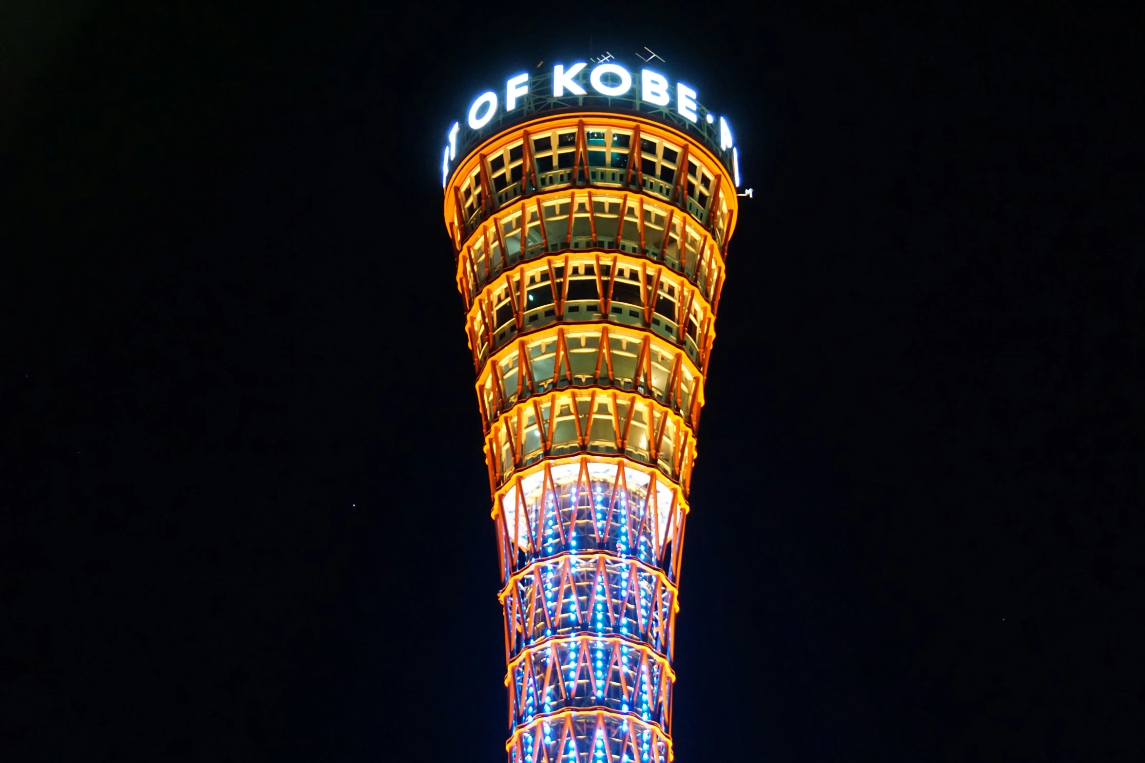 a tall building with lights in it and a tower in the background