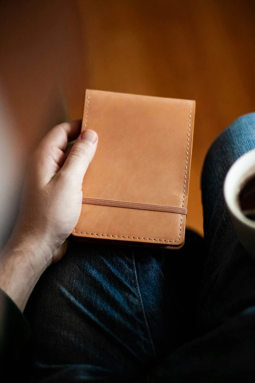 a hand is holding a small piece of brown paper