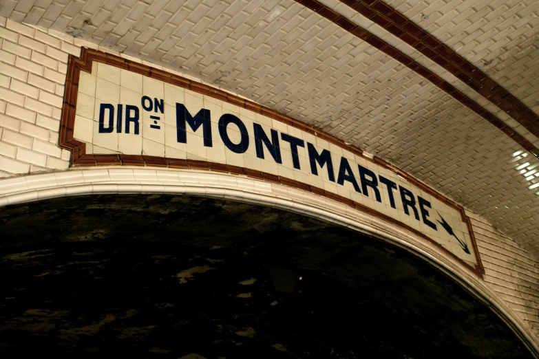 a sign that says dip on the montmarte next to an archway