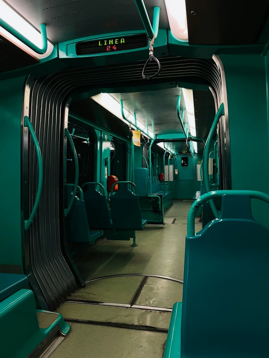 an empty train car with blue seats in a station