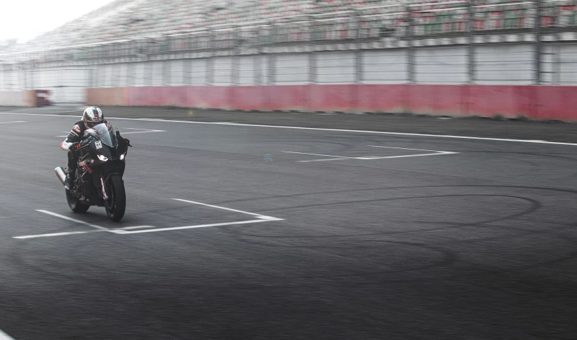 a motorcyclist is on the wet track in the rain