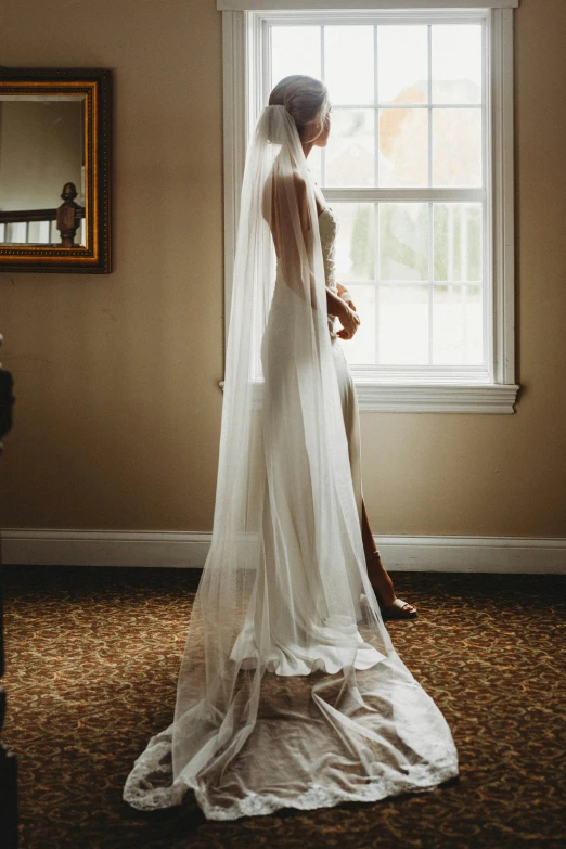 the bride is looking out of the window