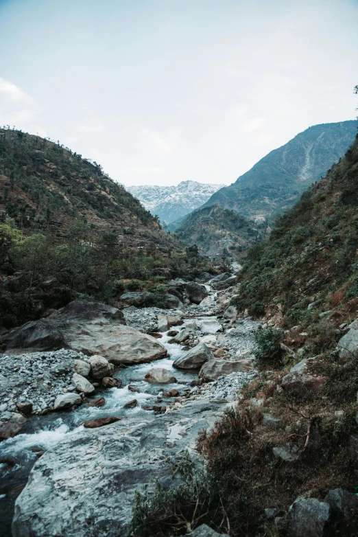 a mountain stream running through a valley in the countryside