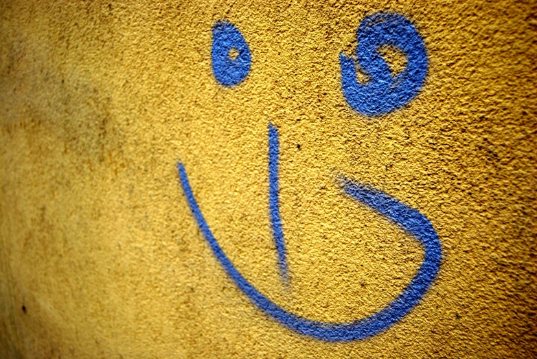 a yellow wall with blue and white lettering that reads smile
