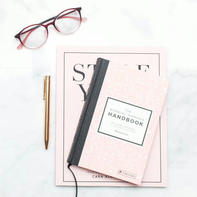 a notebook with eyeglasses and pen laying on a table