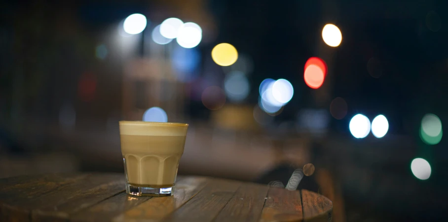 a cup of coffee sitting on top of a wooden table