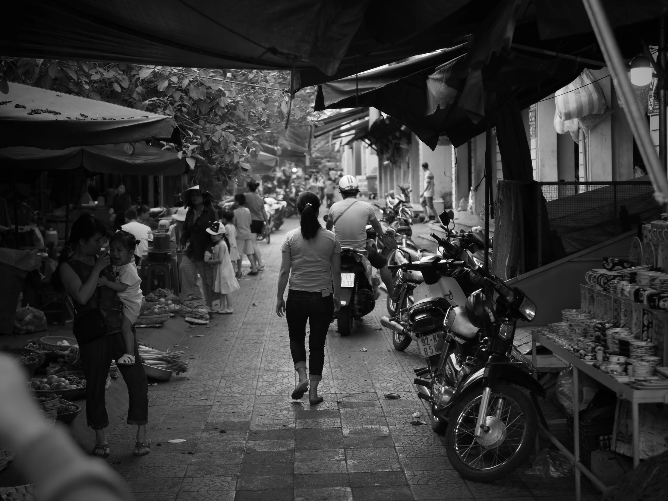 an oriental street with a crowd of people shopping