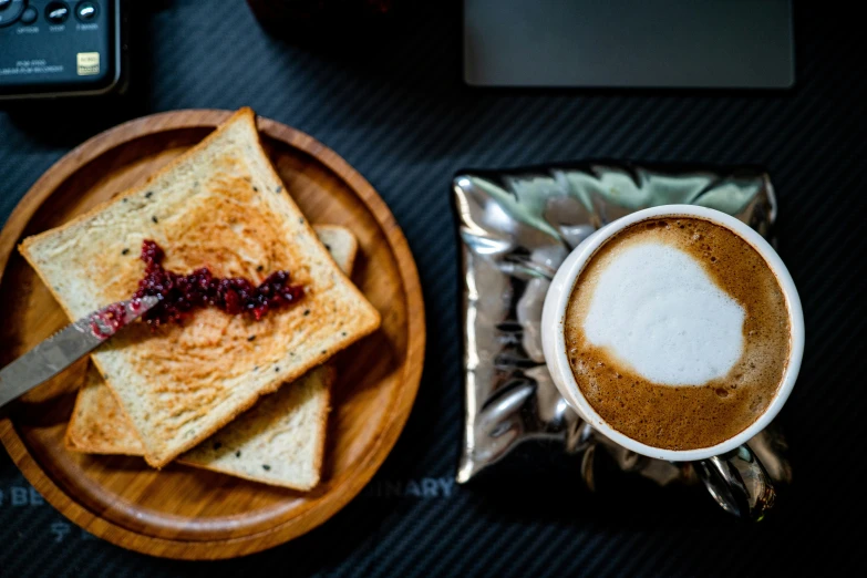 there are some toasts, jelly and coffee on the plate