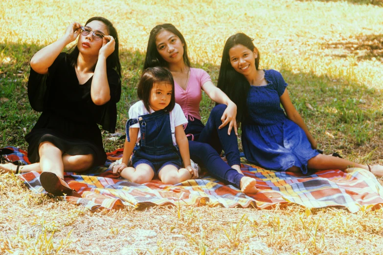 a group of women that are sitting on a blanket