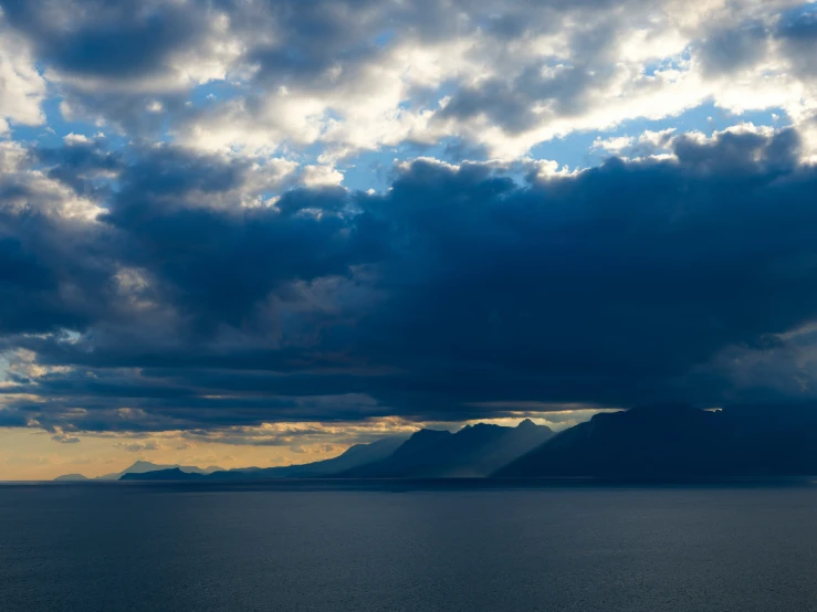 the clouds are coming out over the mountains