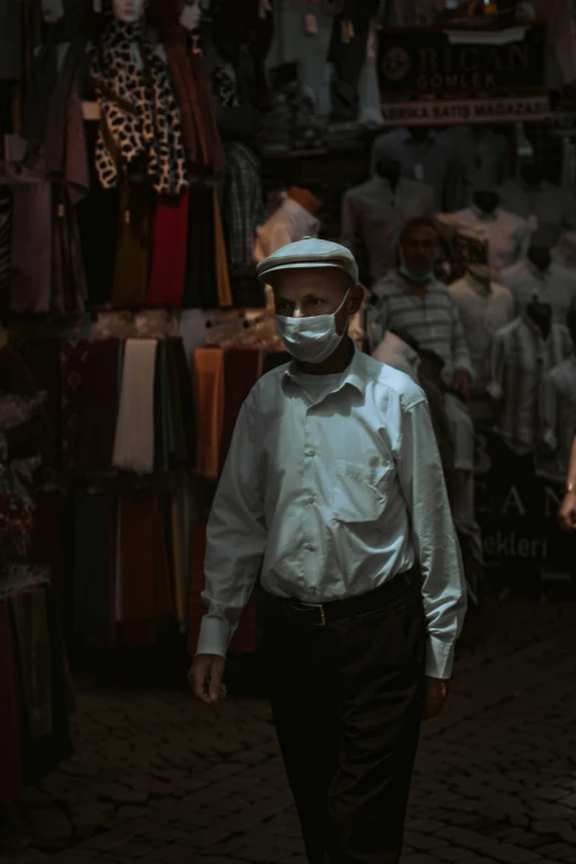 a man wearing a hat and shirt walking down the street