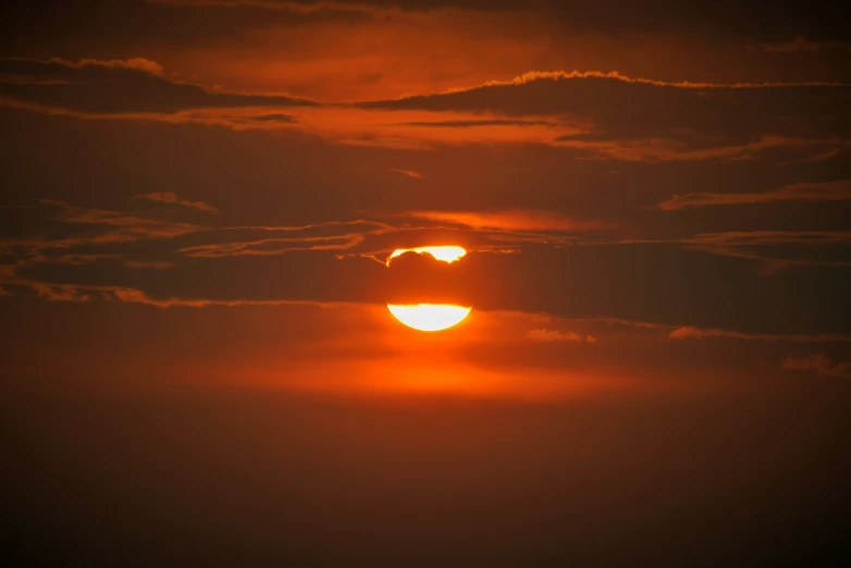 a large orange and yellow sunset with a black background