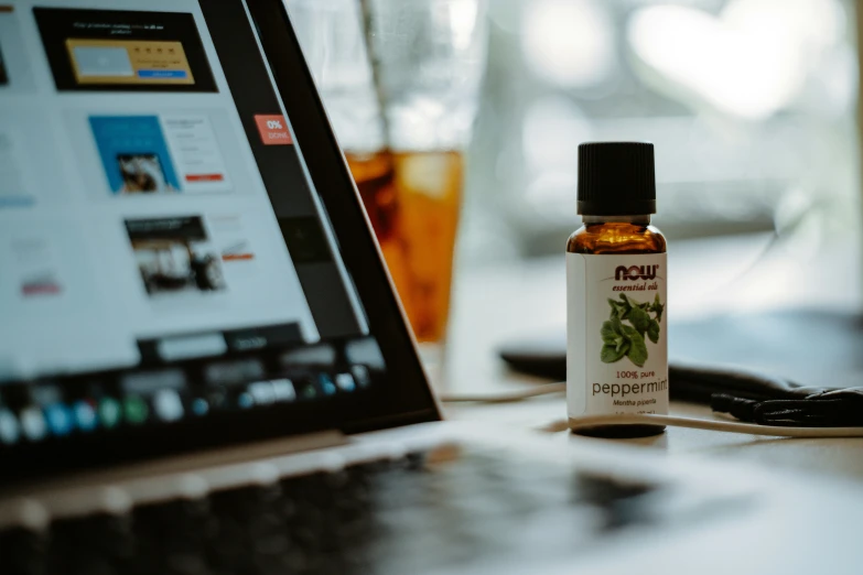 a laptop with an apple in the background next to a tea bottle