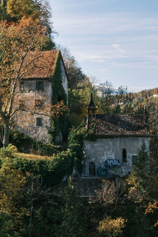 an old building sitting among some trees on a hill