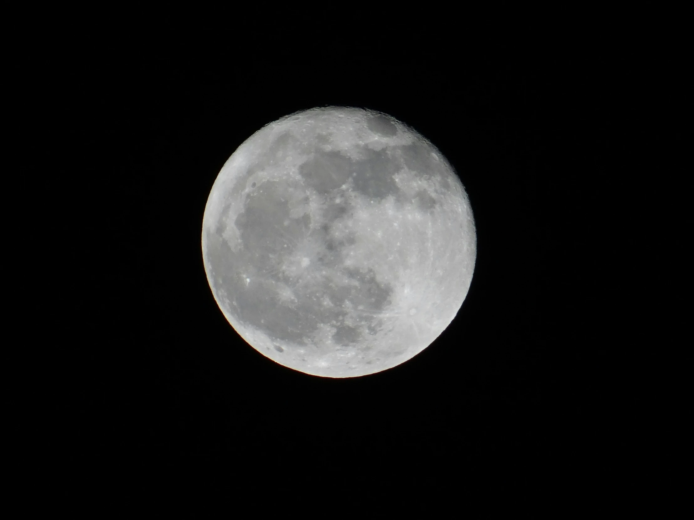 a plane flying in front of the full moon