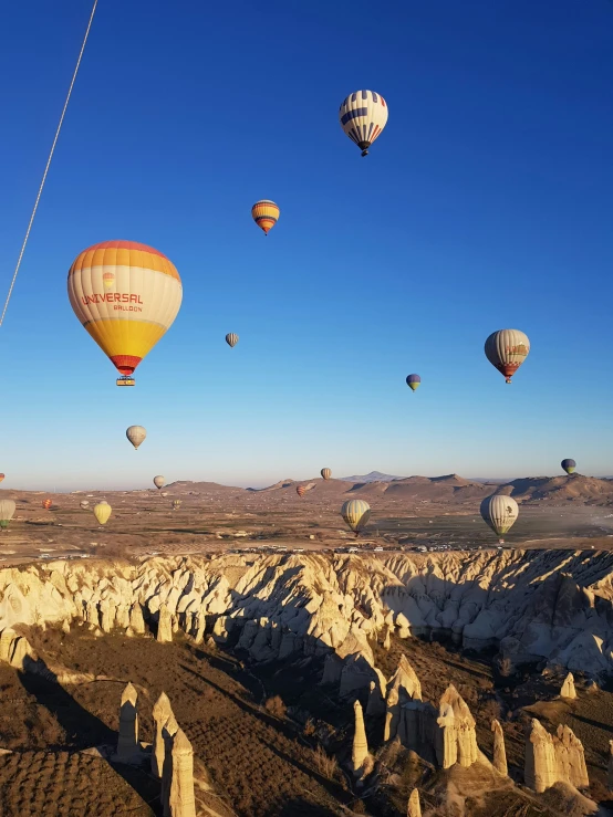 an image of balloons in the air above mountains