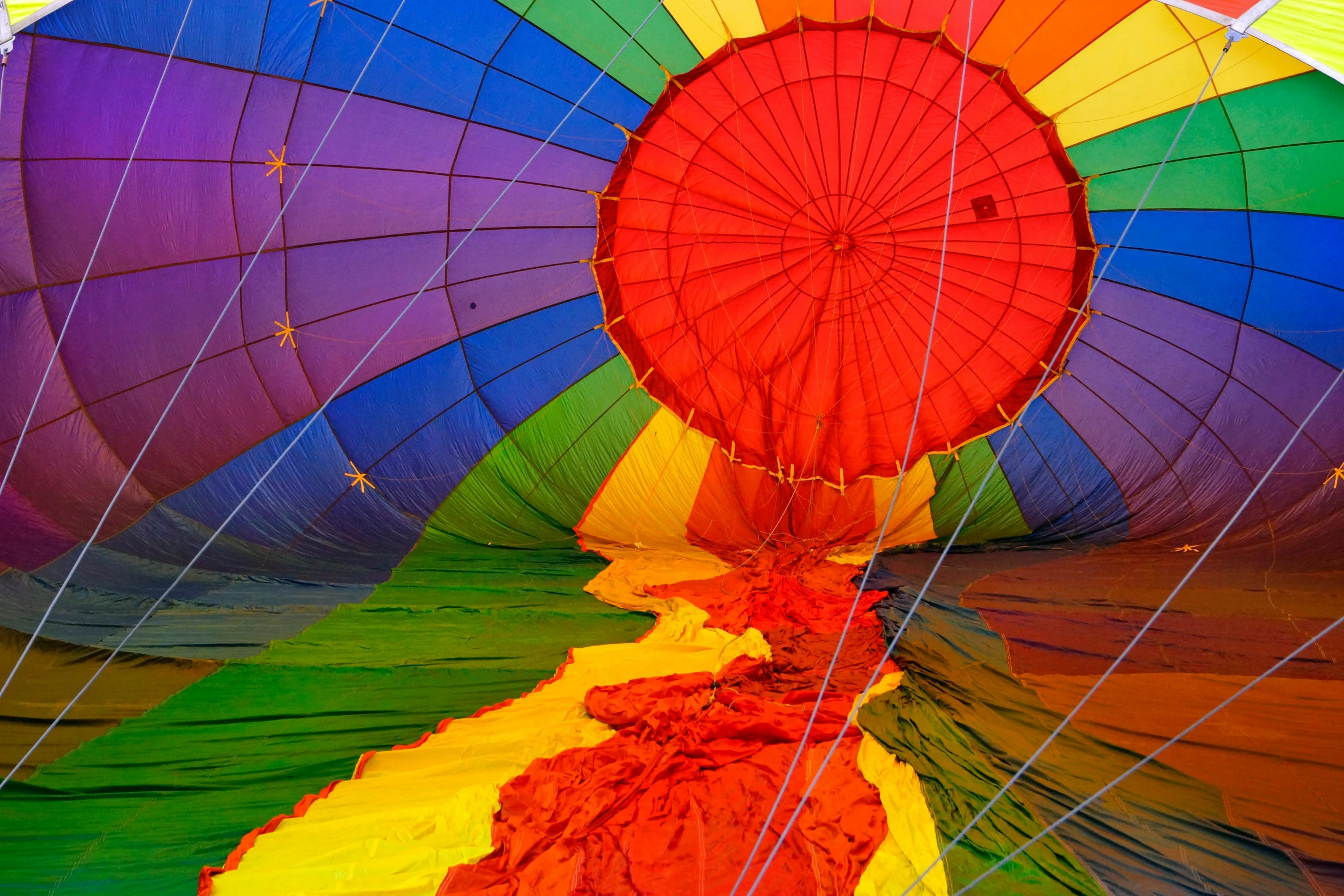 a colorful balloon is on the ground with other  air balloons
