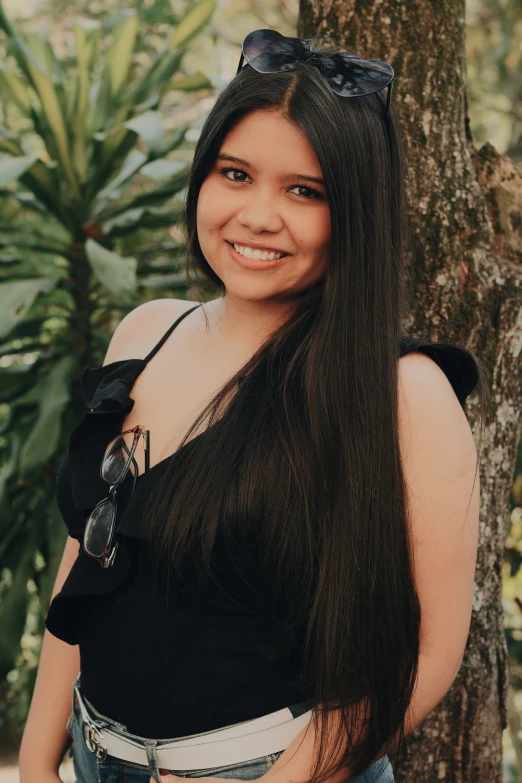 a woman wearing a black top and jeans posing for a pograph