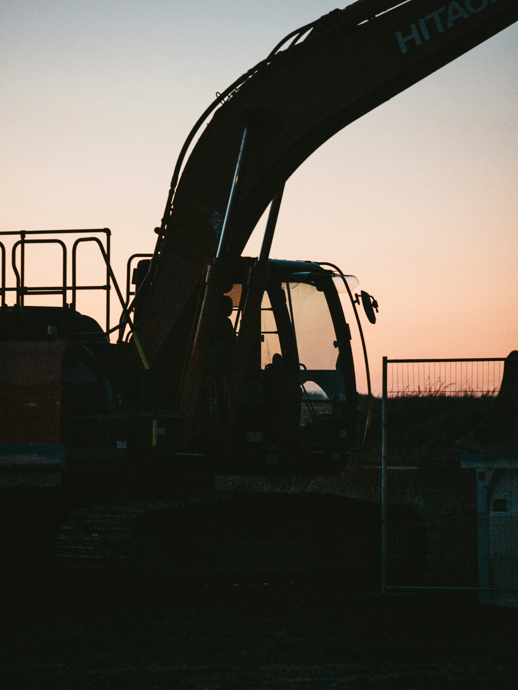 a large machine with a long track is driving behind it