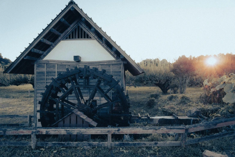 old style waterwheel in front of old wooden building