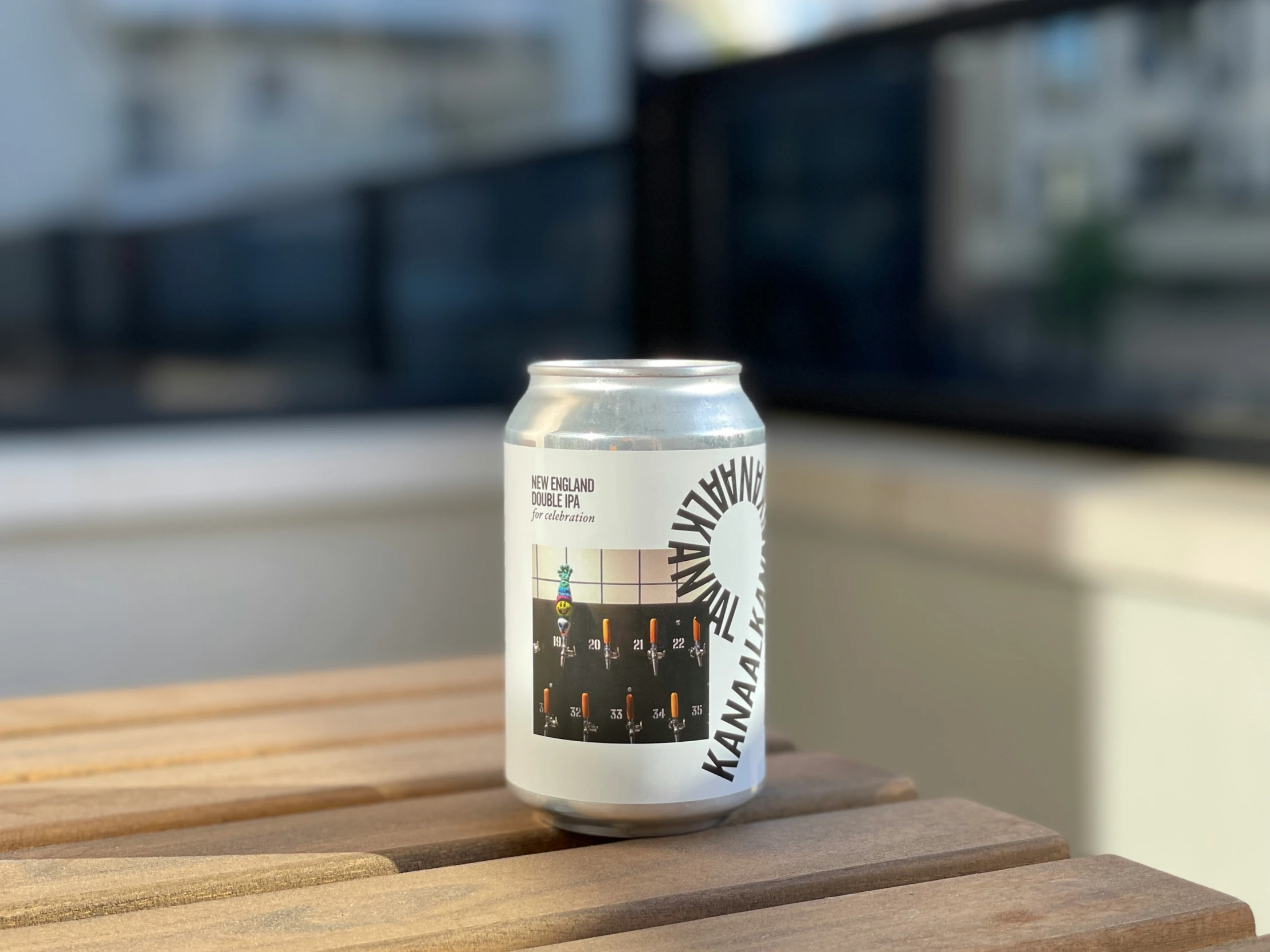 a half empty canned beer can sits on a wooden table