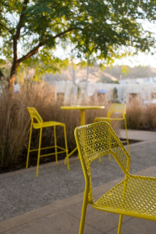 a yellow chair sits in front of some green tables