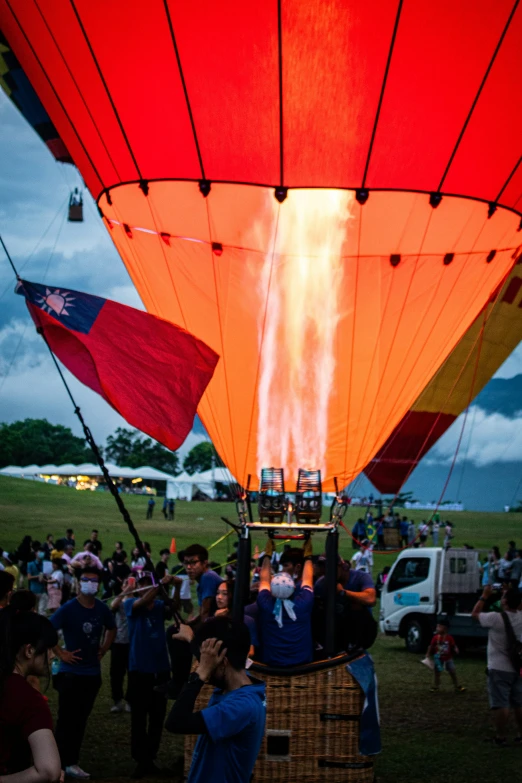 a crowd of people standing around a  air balloon