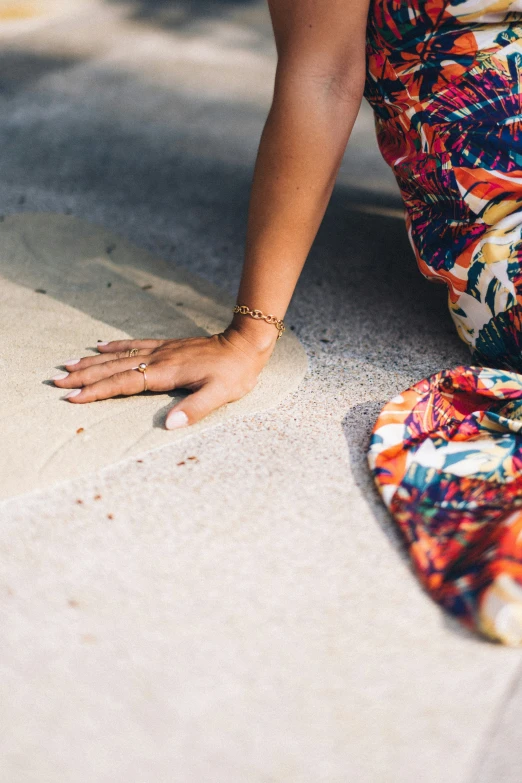 a woman squatting on the ground in a colorful dress