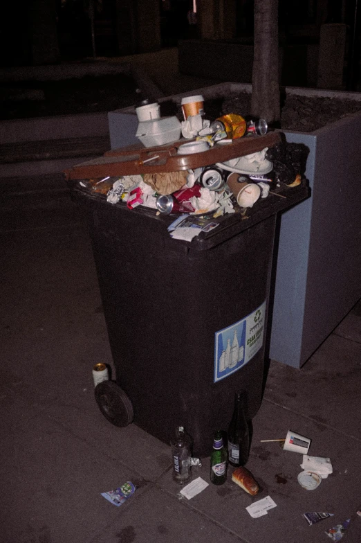 a large trash can sitting on the sidewalk