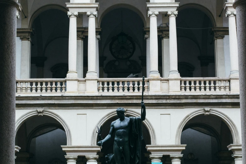 a statue in front of a stone building