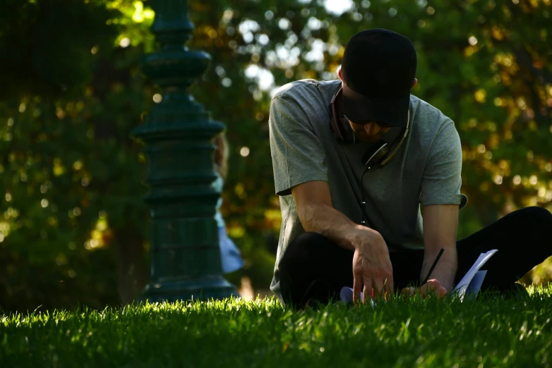 the man sits in the park and adjusts his book