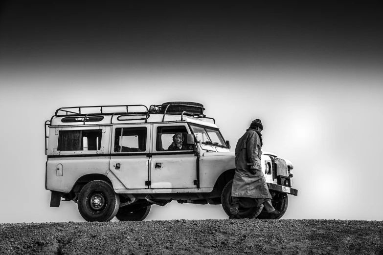 a man walks towards a vehicle with surf boards on top