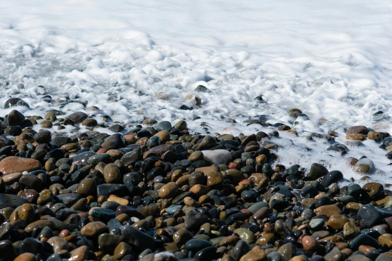 some rocks in the water at the beach