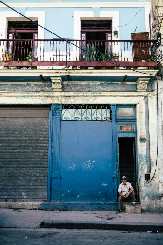 there is a person sitting in the doorway of a building