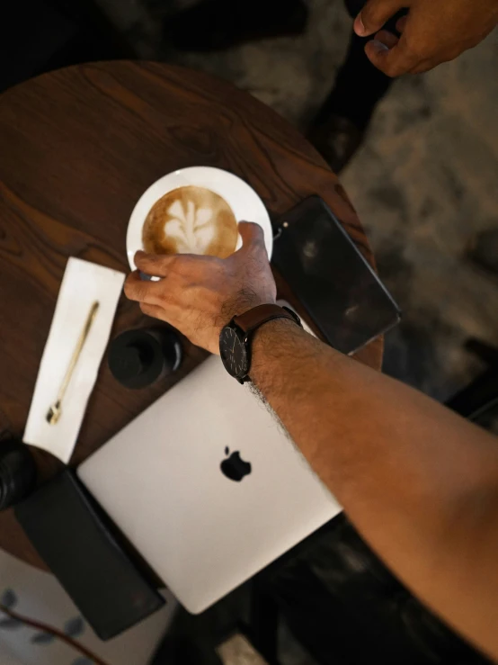 someone is making soing at a table in front of an apple laptop