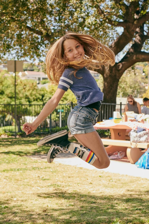 a  is jumping in the air with her skateboard