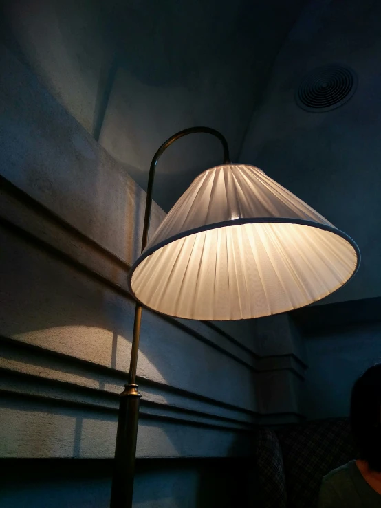 a lamp sits against a blue wall in a dimly lit room