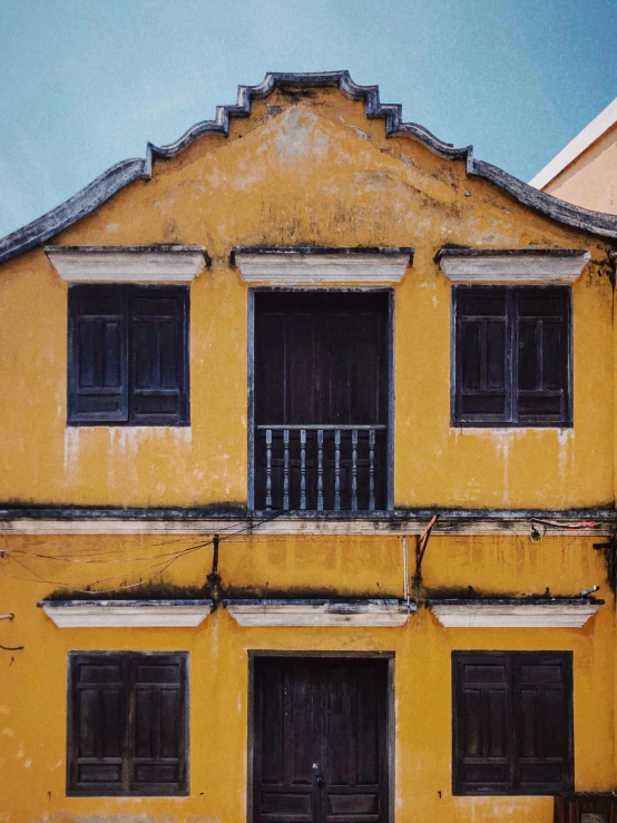 the front of a tall yellow building with lots of windows