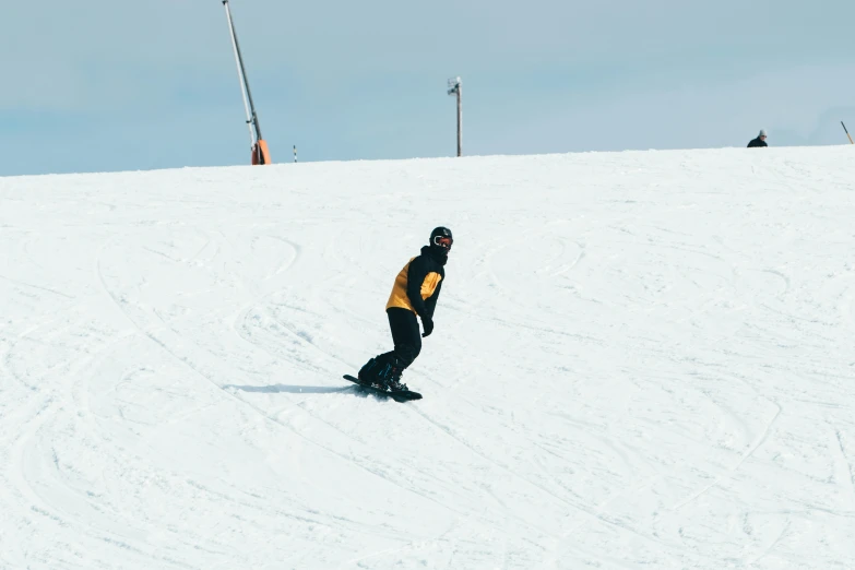 a man riding a snowboard down a snow covered slope