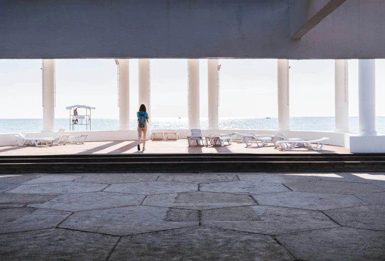 the back end of a person standing in a building by a beach