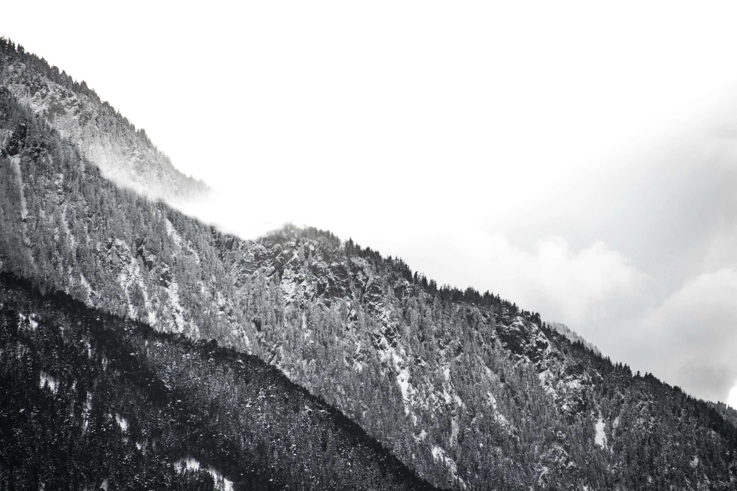 a large mountain with clouds in the background